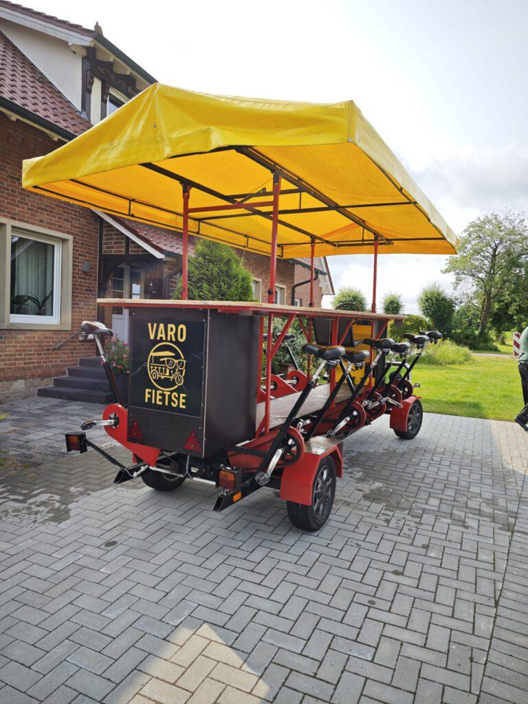 VaroFietse – Bierbike mit gelbem Dach und seitlichen Pedalplätzen